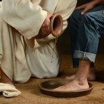 Jesus Washing Feet of Man in Jeans