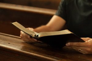 Man reading Bible in a church