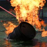 Barrel of oil on fire floating in water