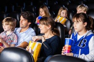 Families having snacks while watching movie in cinema theater