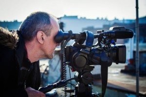 cameraman with his video camera shooting outdoor in the city on roofs