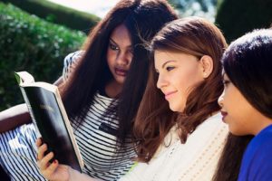 Three Christian girls studying the Bible as a group